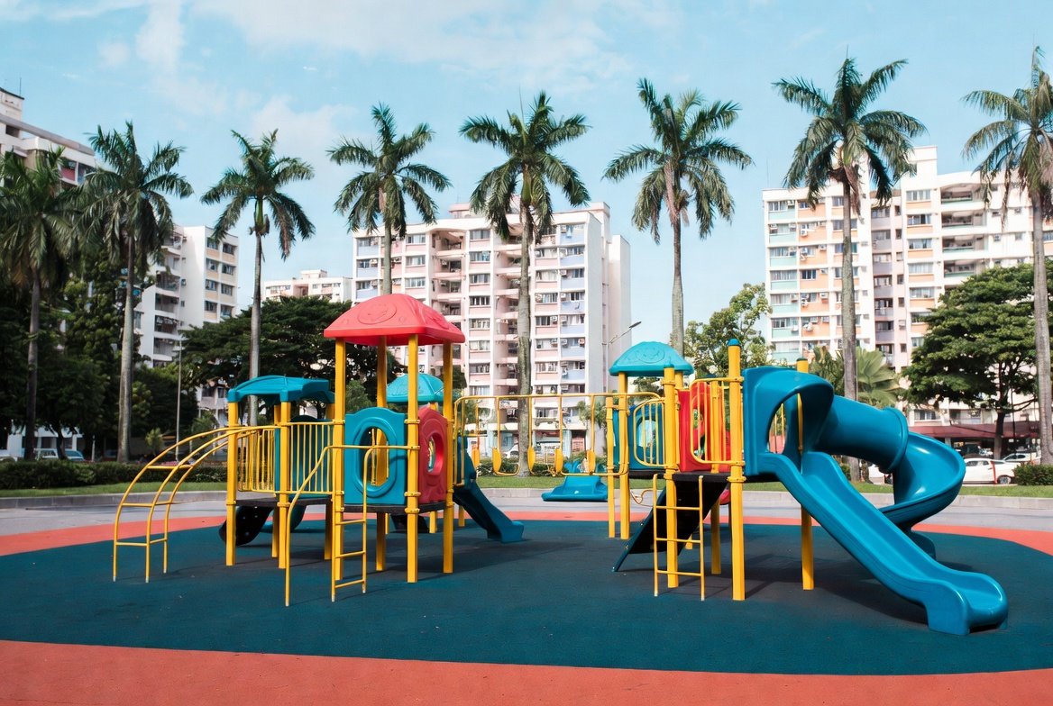 Children playing on a colourful community playground in a Singapore neighbourhood park.